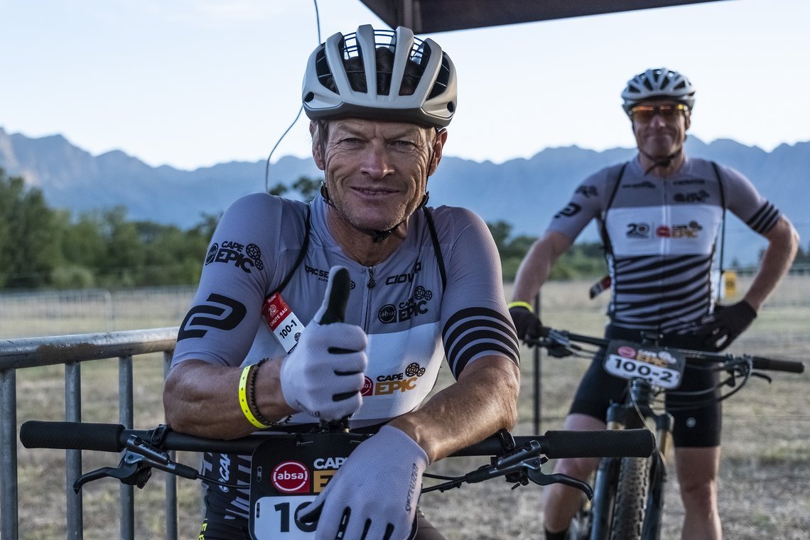 Guten Morgen Cape Epic! Es geht bereits früh morgens los. Heute fiel der Start um 7 Uhr für die 88 km lange Etappe rund um Saronsberg. Barti Bucher und Peter Furrer, führende in der Kategorie Great Grand Masters haben gute Laune.