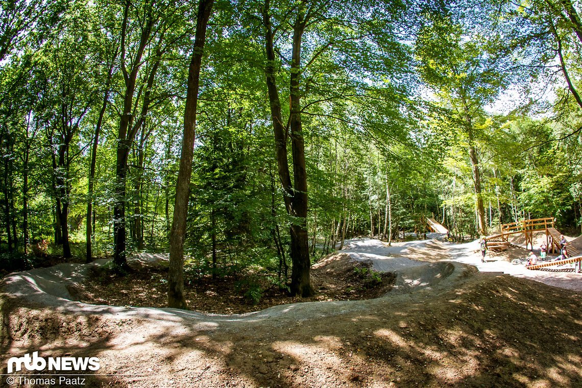 Im Vordergrund ein Teil des Pumptracks, im Hintergrund der Startturm der Tableline, Abfahrtsrampe, kleine Dropbatterie und Wippe