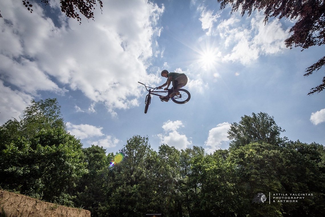 Fahrer Chris Haas fliegt auf seinem BMX über die perfekt geshapten Dirts