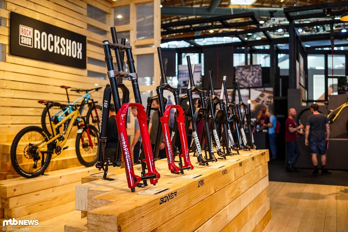RockShox präsentiert auf einem luftigen Stand die neuen Boxxer und Lyrik Modelle (rot), gefolgt von der gesamten Modellpalette bis hin zur leichten SID oder RS-1