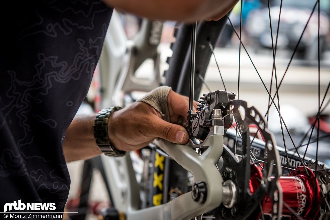 Währenddessen werden die Bremsen am Bike von Loris Vergier gepflegt