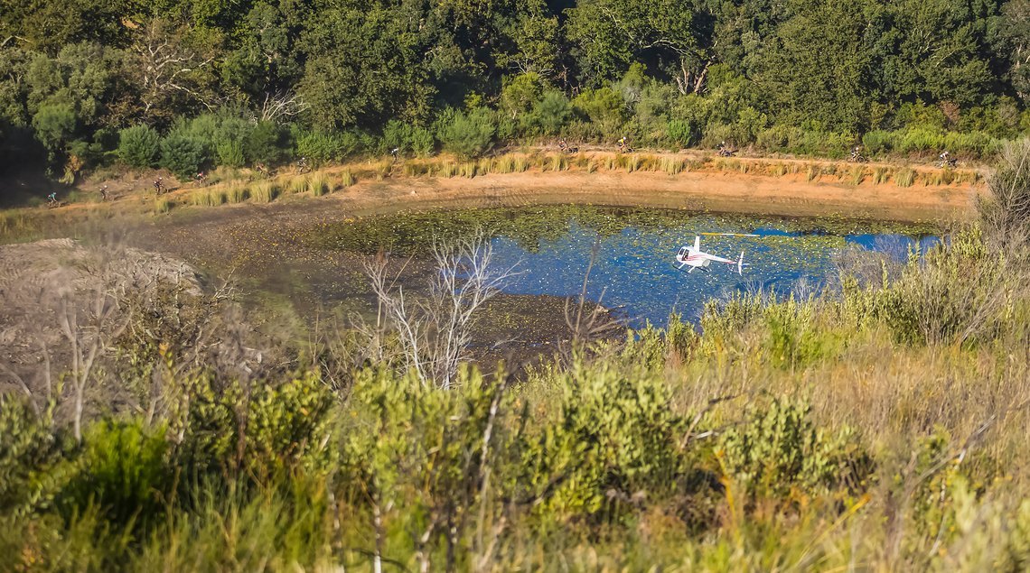 The Lead men pass a dam during stage 1 of the 2022 Absa Cape Epic Mountain Bike stage race from Lourensford Wine Estate to Lourensford Wine Estate, South Africa on the 21st March 2022. © Dom Barnardt / Cape Epic