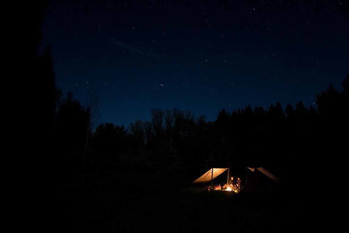 Das Licht des Feuers setzt Florians Tarp-Konstruktionen in Szene