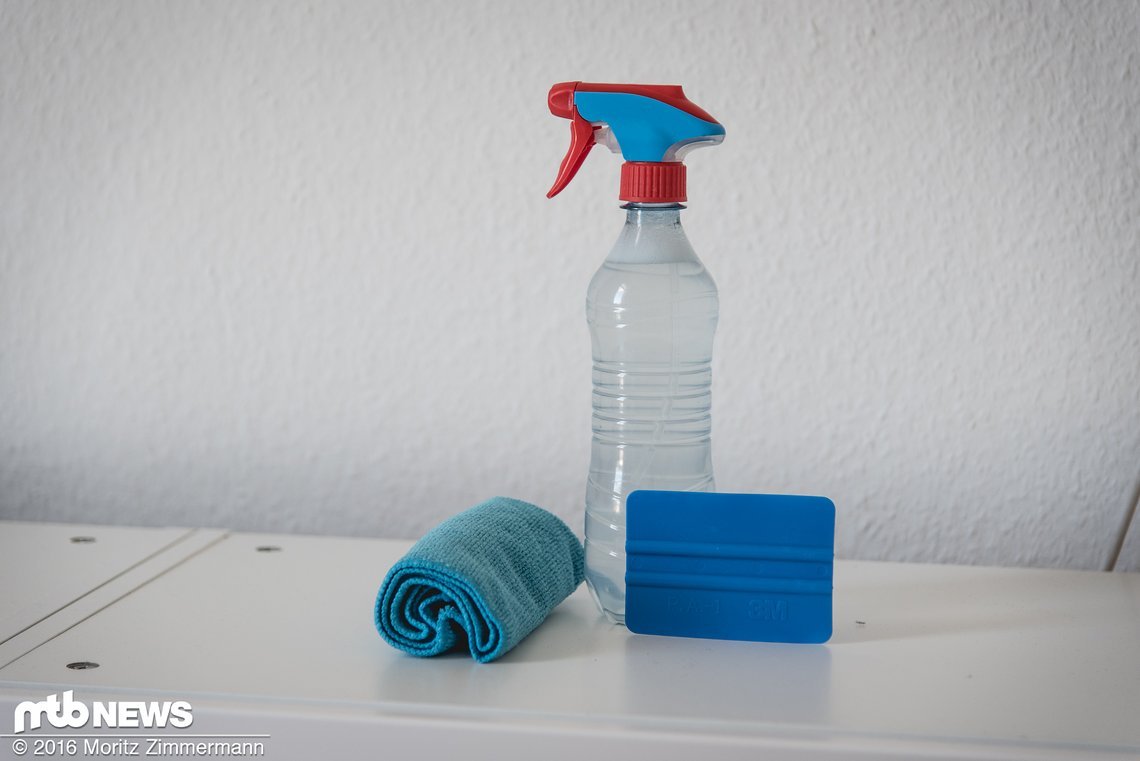 Neben dem Aufkleber-Set benötigt man ein fusselfreies Tuch, um den Rahmen gründlich zu reinigen, einen kleinen Rakel und eine Wasserflasche mit Sprühkopf