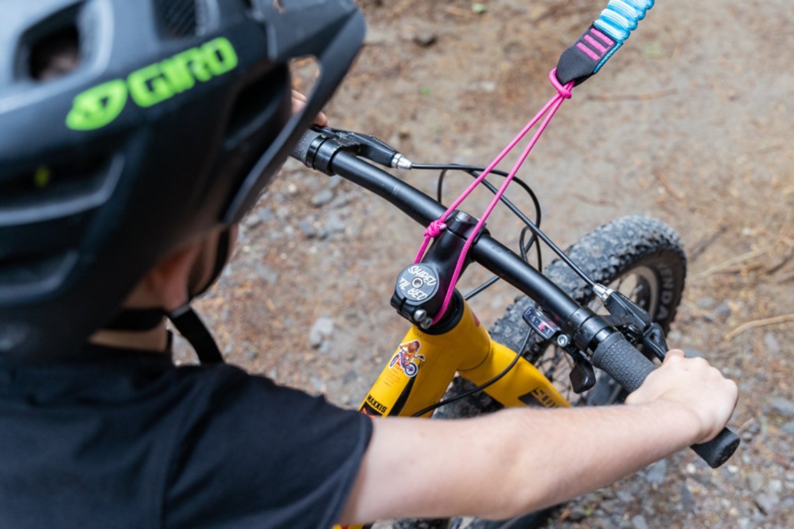 Am Kinderbike wird das Seil entweder mit einer Schlaufe unter dem Vorbau …