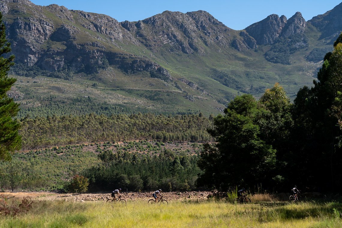 Riders skirt the edge of Lourensford dam during stage 1 of the 2022 Absa Cape Epic Mountain Bike stage race from Lourensford Wine Estate to Lourensford Wine Estate, South Africa on the 21st March 2022.