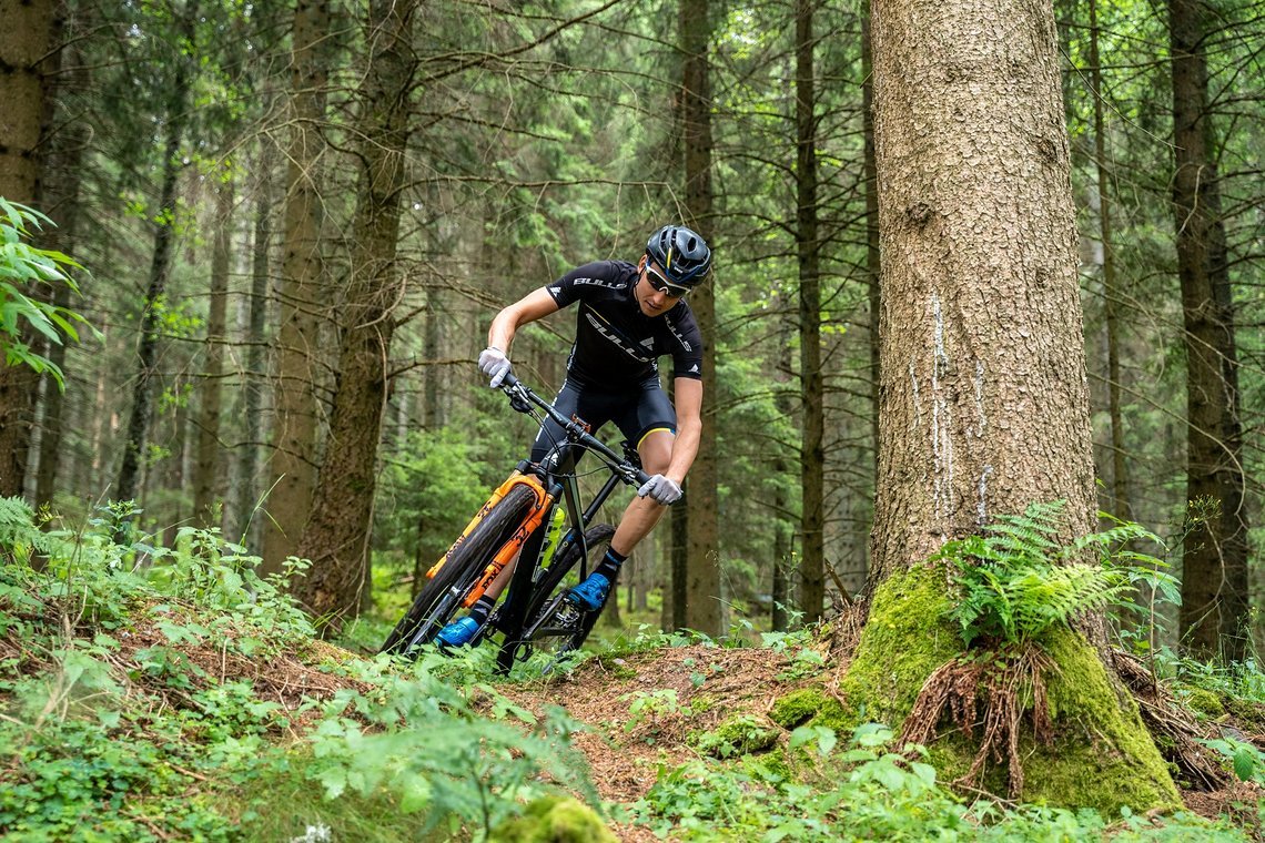 Auch mit hohem Sattel fetzen die Bike-Profis mit ordentlich Speed durch die Kurven im Gelände