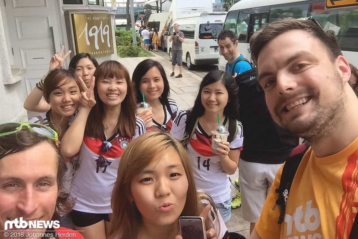 Peace - Singapurerinnen sind begeistert, dass wir Deutsche sind. Schließlich tragen alle das Trikot der Deutschen Nationalmannschaft. Da musste ein Foto her