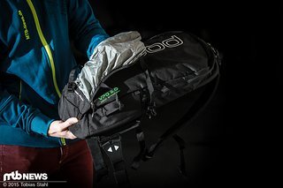 Die Helmhalterung ist ein einem kleinen Fach unten am Rucksack untergebracht und wird an vier Punkten eingehängt Die Helmhalterung ist ein einem kleinen Fach unten am Rucksack untergebracht und wird an vier Punkten eingehängt