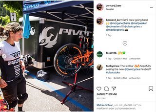 Morgane Charre steht neben dem quietsch-orangen Enduro Morgane Charre steht neben dem quietsch-orangen Enduro