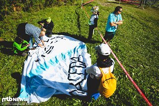 Letzte Vorbereitungen am Streckenrand. Die Banner müssen hängen wenn's gleich losgeht!