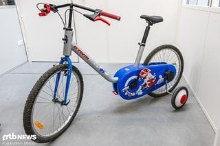 Dabei sind nicht nur die Bremsgriffe anders, auch Kettenschutz und Stützräder sind für das Kinderbike-Feeling montiert.