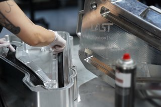 Die Carbon-Prepregs werden in der Negativform des Hinterbaus drapiert. Die Carbon-Prepregs werden in der Negativform des Hinterbaus drapiert.