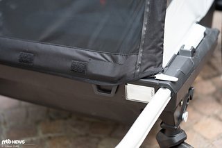 Das Verdeck wird vorne links und rechts eingehängt (schwarzer Griff), zusätzlich wird es mit zwei Gummizügen gespannt (weißer Hebel oben auf der Deichsel
