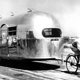 French bike racer Alfred Letourneur towing a 22 foot long Airstream Liner at the Metropolitan Airport in Van Nuys, California to demonstrate how light it was, 1947