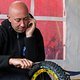 Multitasking - CRC Teammanger Nigel Page schneidet parallel zum telefonieren die stollen an den Schwalbe Reifen